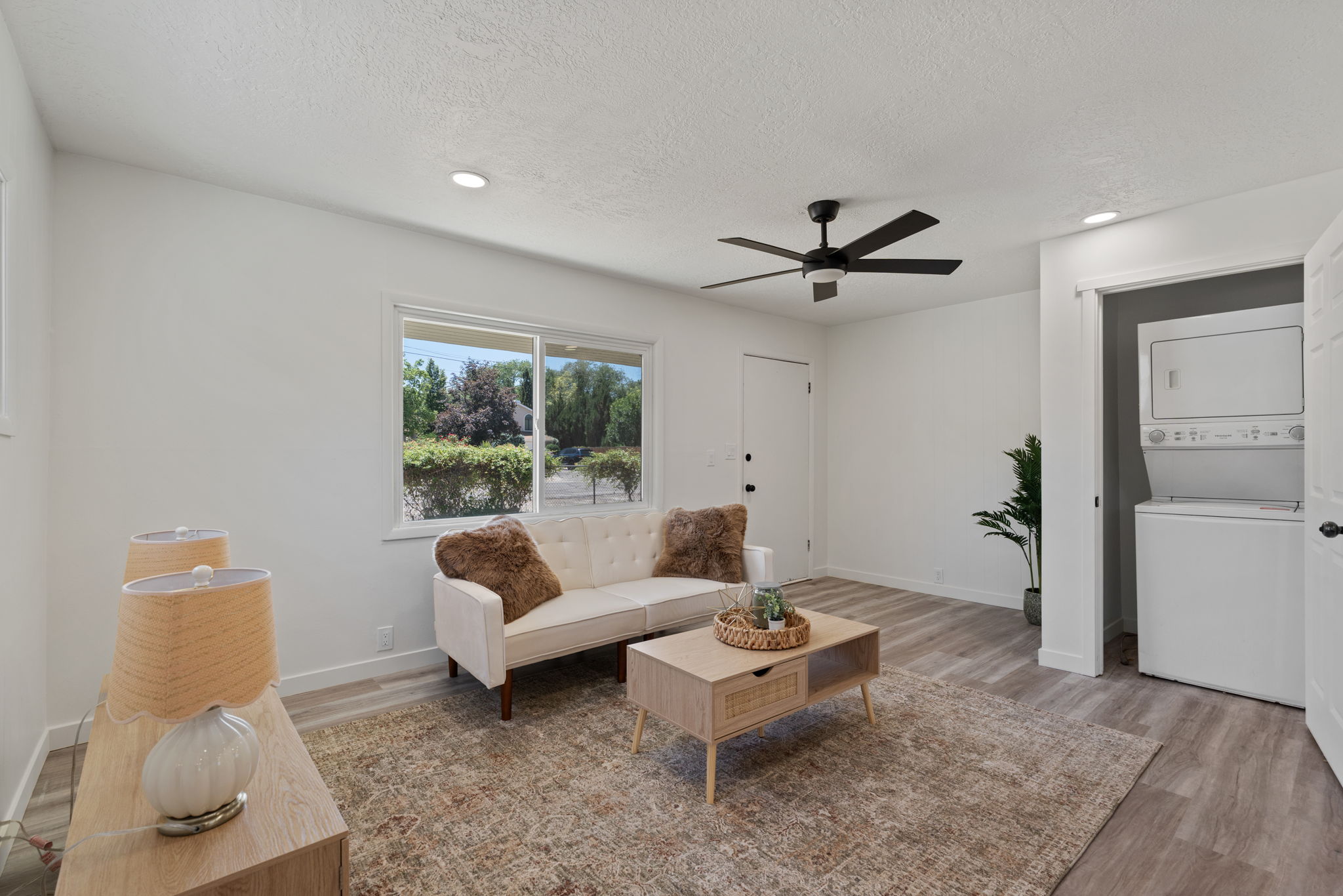 Living space featuring wood-finish flooring, a ceiling fan with integrated lighting, and recessed ceiling lights