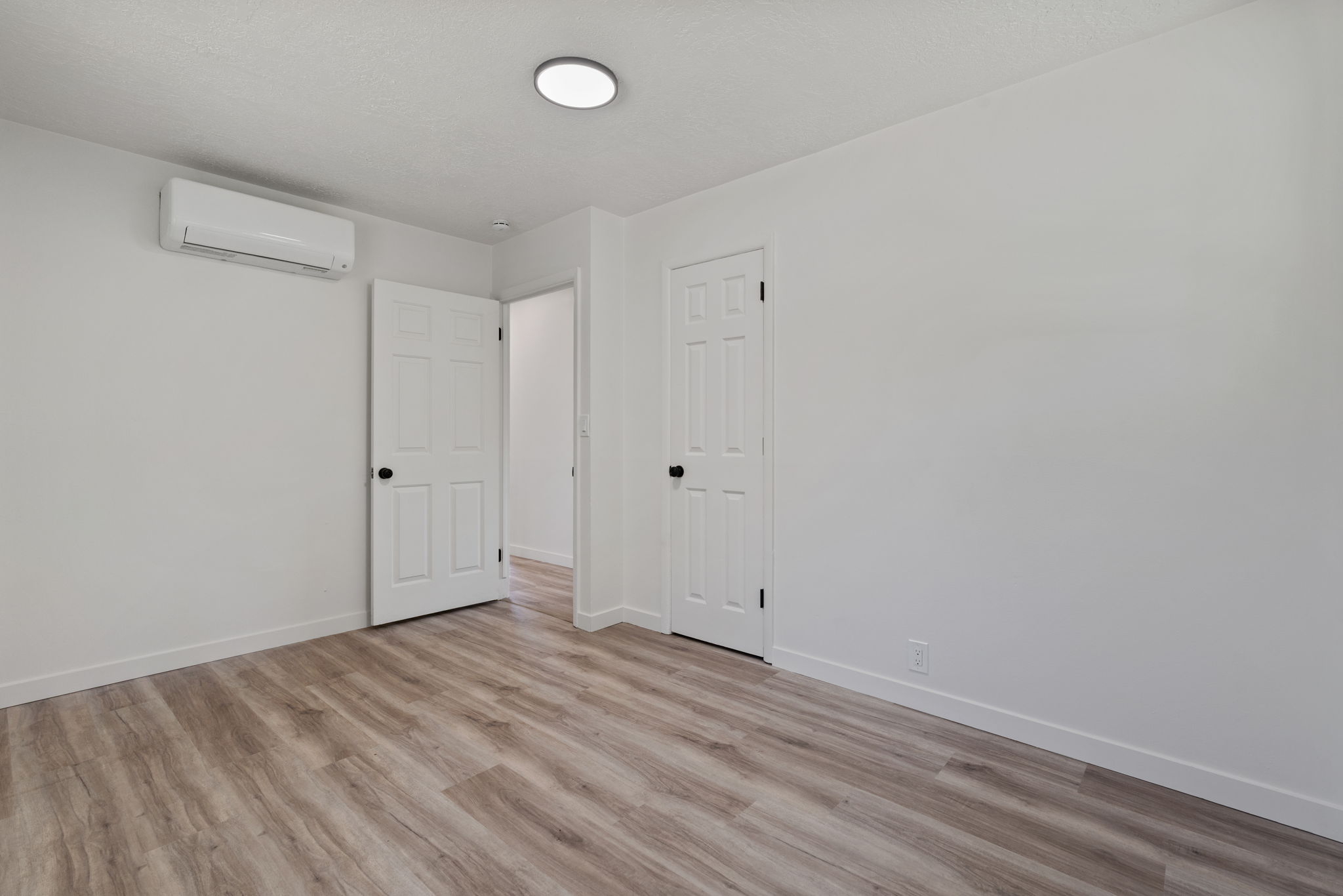 Interior room with wood-finish flooring and white walls