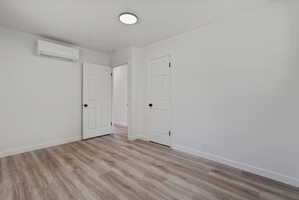 Interior room with wood-finish flooring and white walls