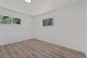 Room featuring wood-finish flooring, white baseboards, and neutral wall paint