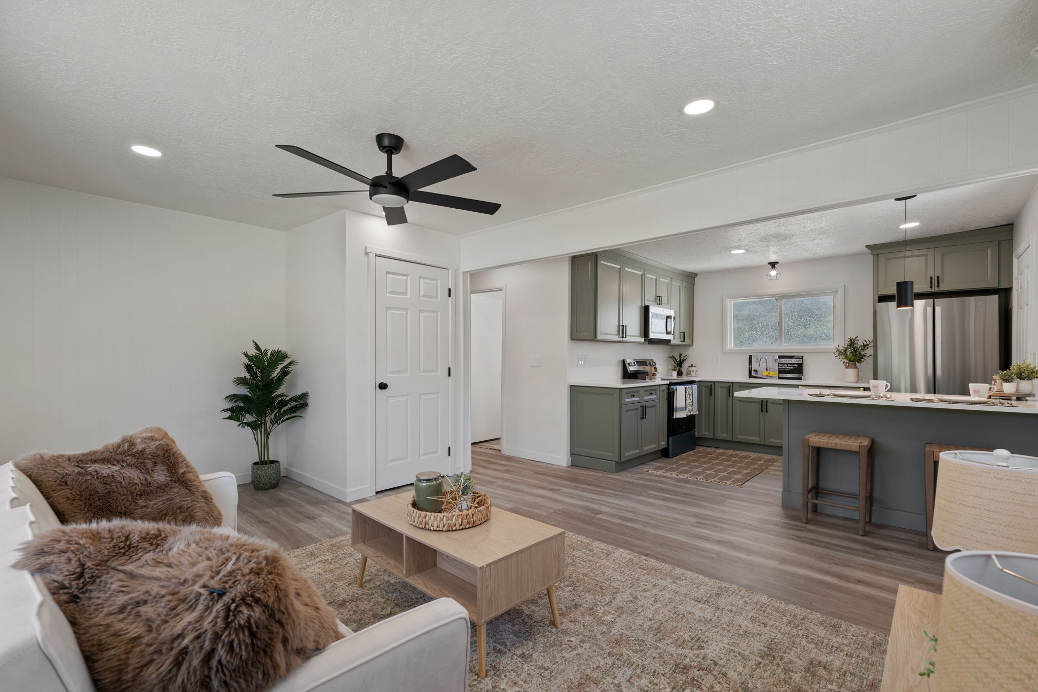 Open-concept living area featuring wood-finish flooring and recessed lighting