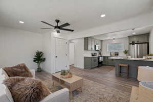 Open-concept living area featuring wood-finish flooring and recessed lighting