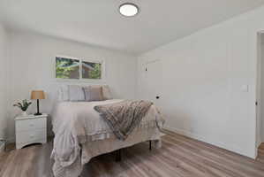 Bright interior space featuring wood-finish flooring, white paneled walls, and a recessed ceiling light fixture