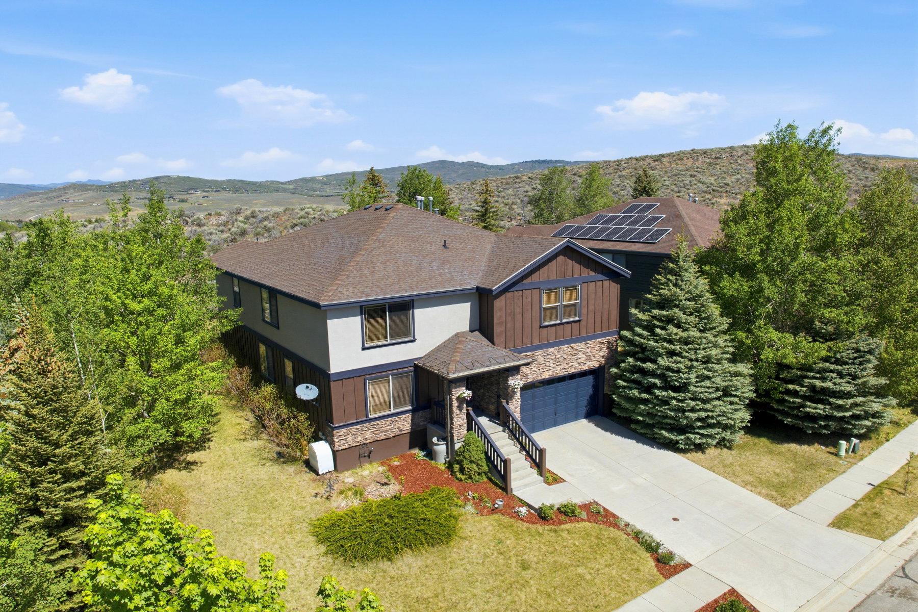Contemporary two-story residence featuring a combination of siding, stone, and wood-paneled accents