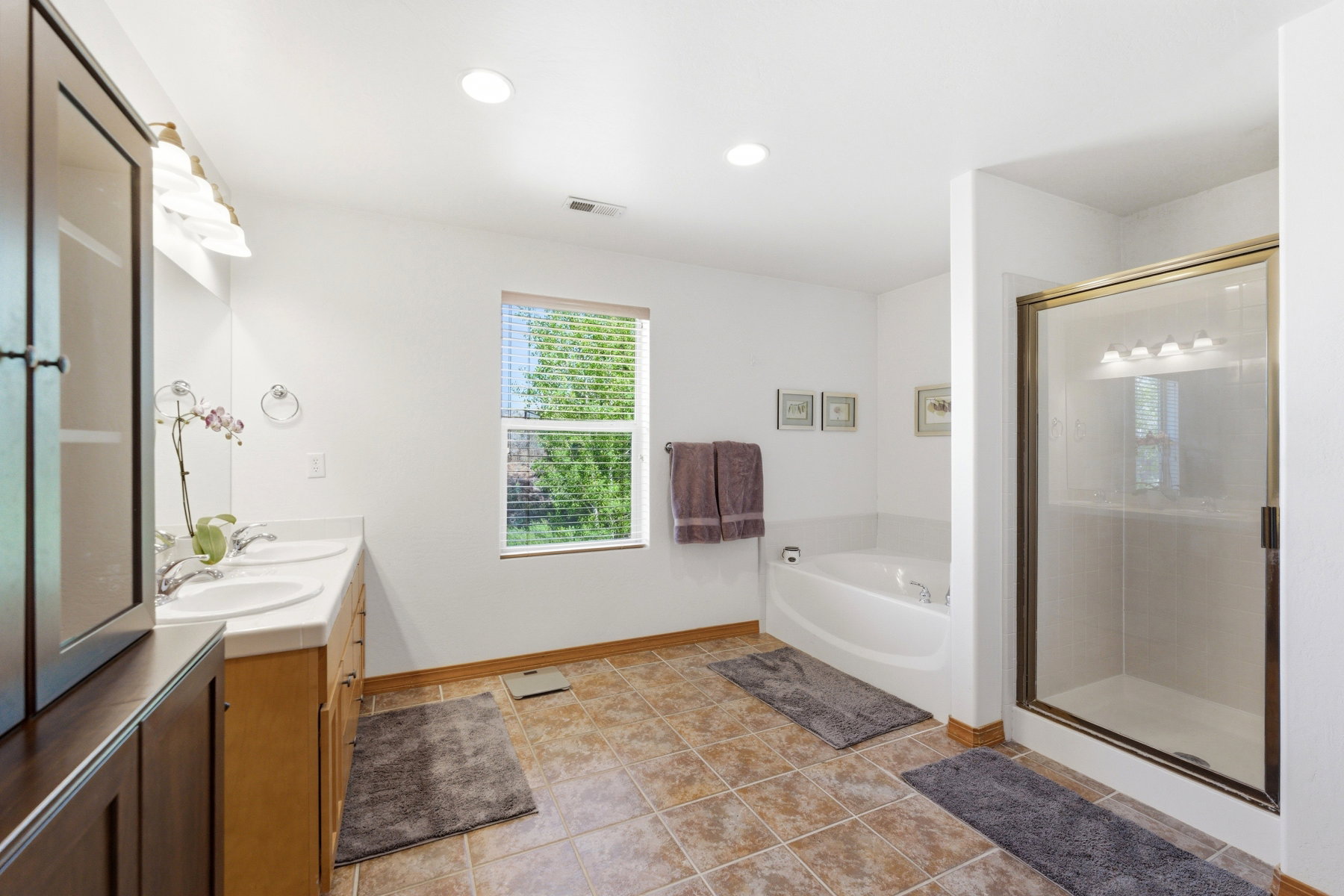Bathroom featuring a dual vanity with light wood cabinetry and white countertops