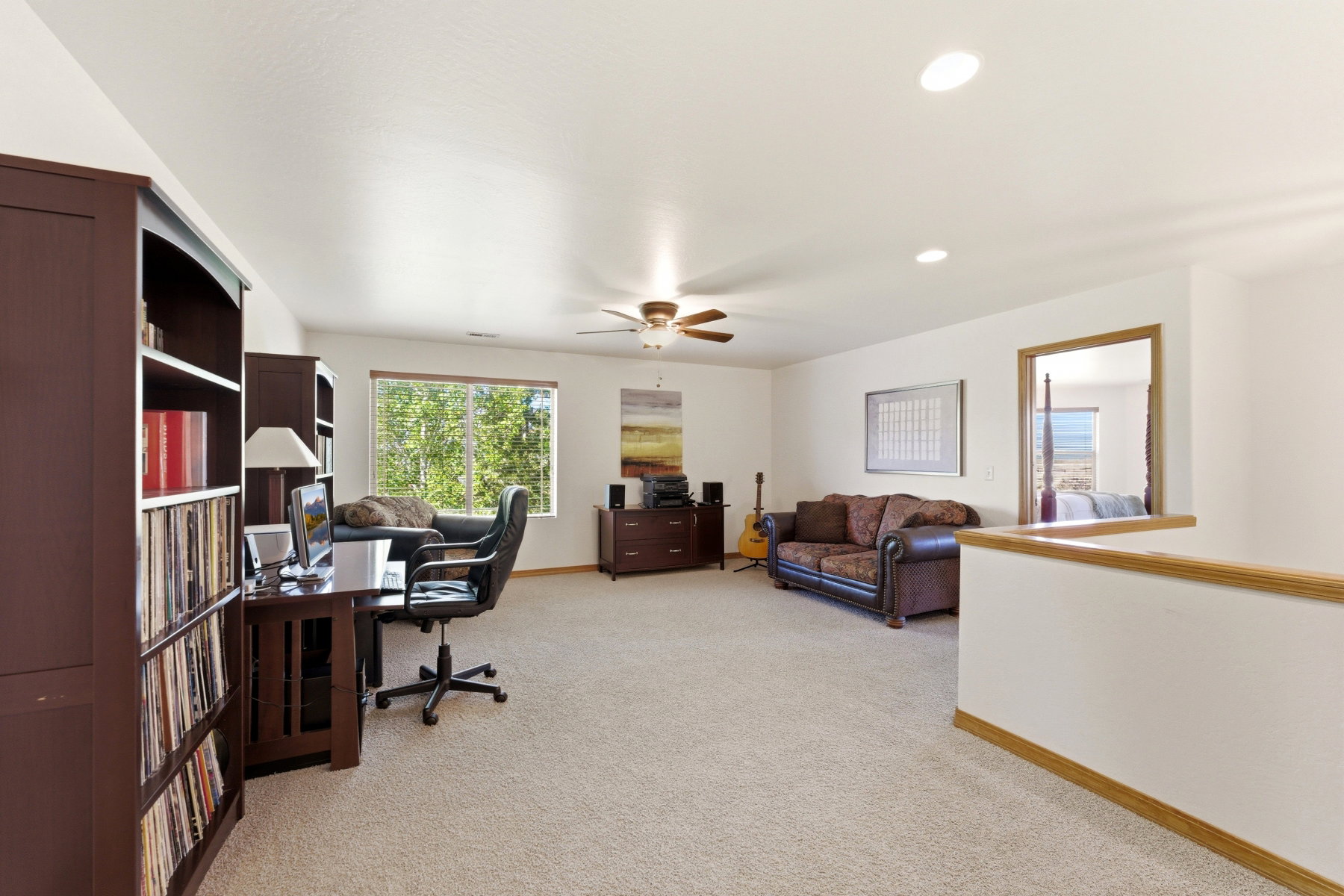 Spacious upper-level room featuring soft carpet flooring and recessed lighting