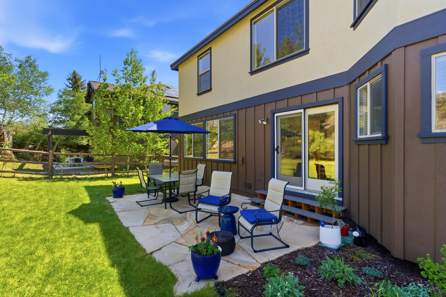 Patio area featuring flagstone pavers, a sliding glass door, and a brown wood-paneled exterior