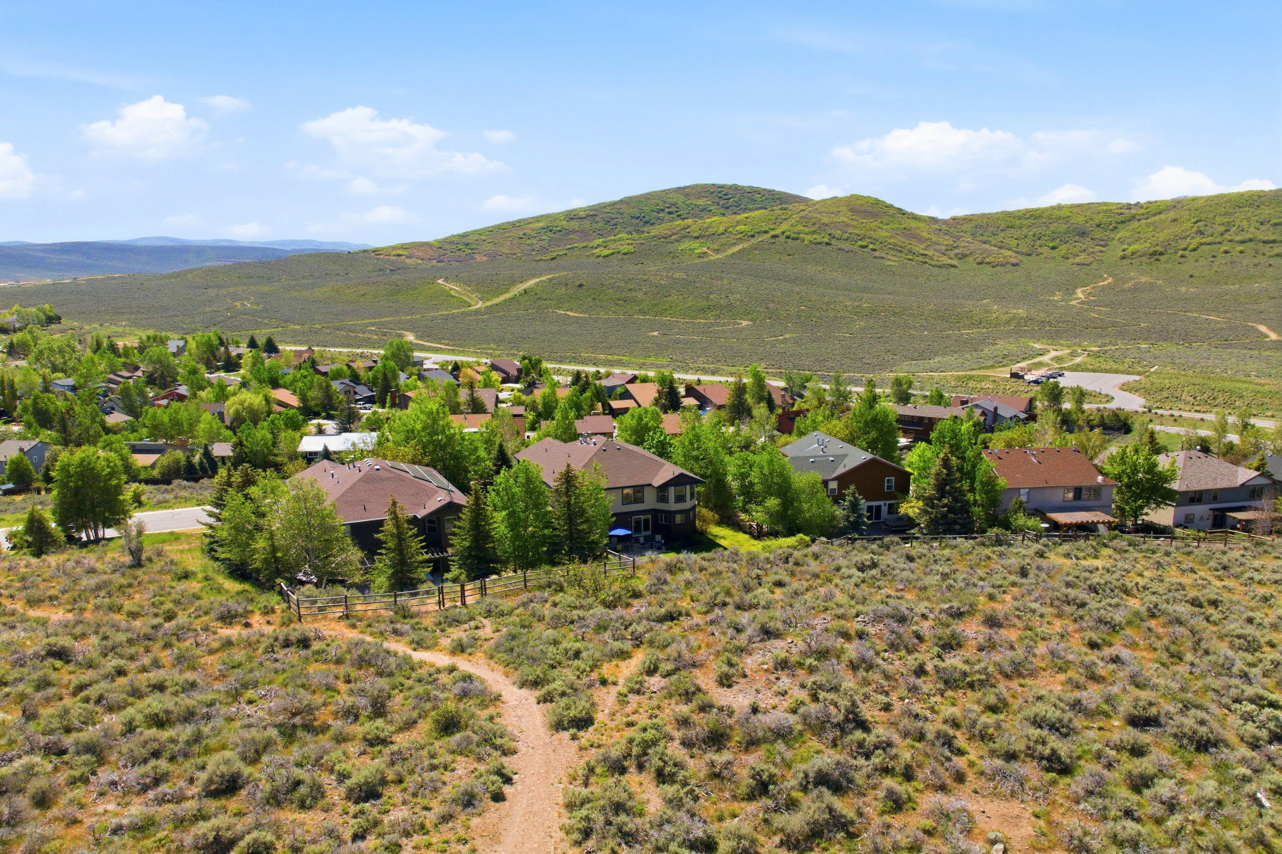 Residential community nestled within a natural landscape of undulating hills and abundant greenery