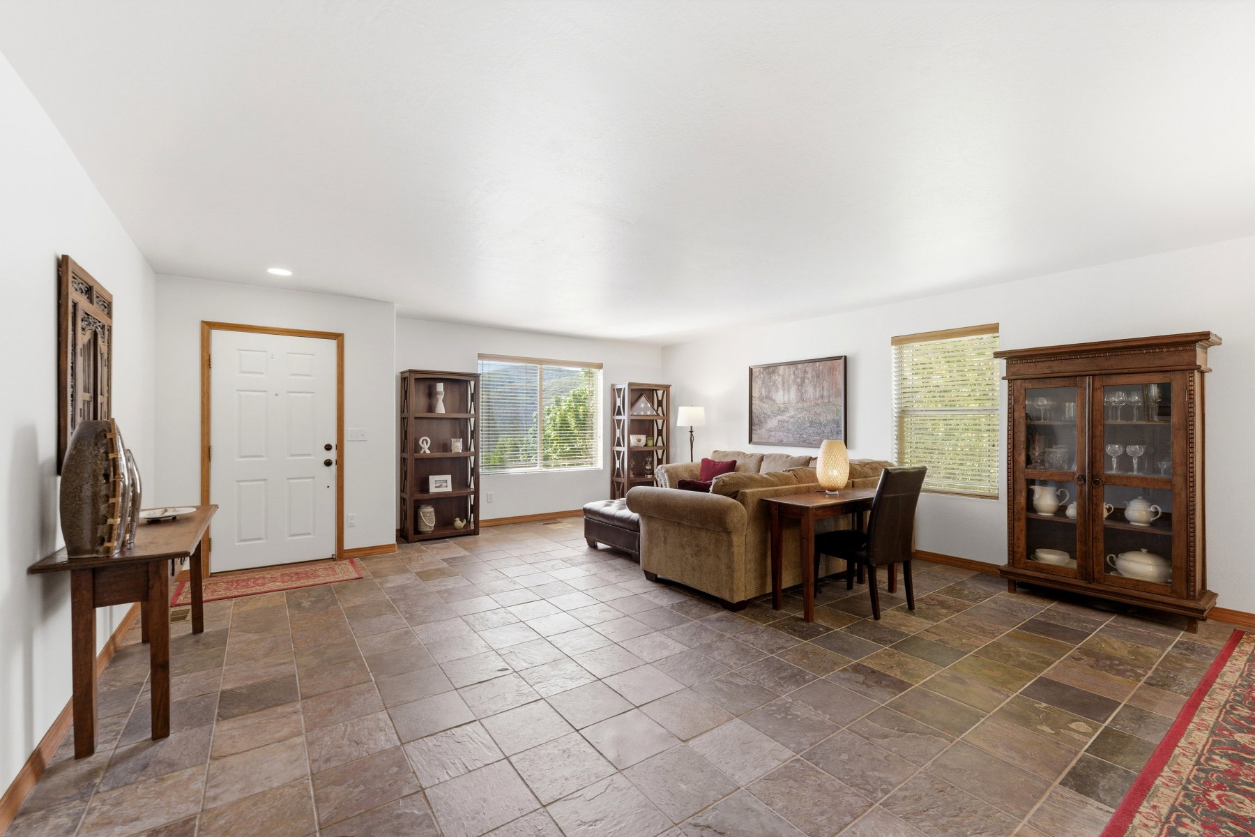 Spacious interior featuring large format tile flooring, white walls, and multiple windows providing natural light