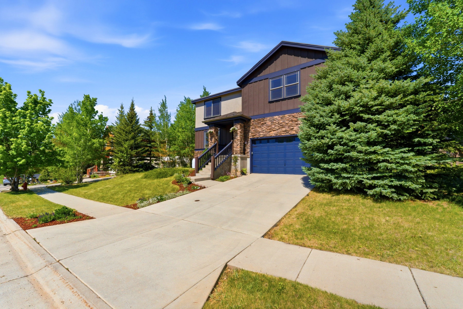 Contemporary home with stone accents and a vibrant blue garage door
