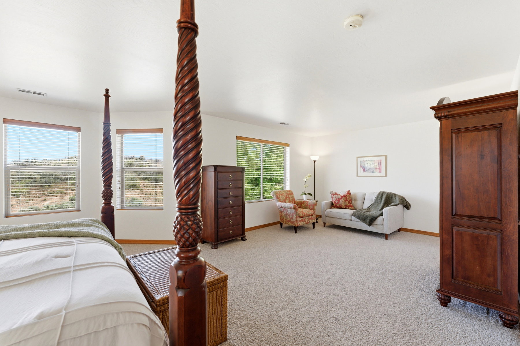 Spacious interior featuring neutral carpeting, multiple windows with natural light, white wall finishes, and wood-finish trim