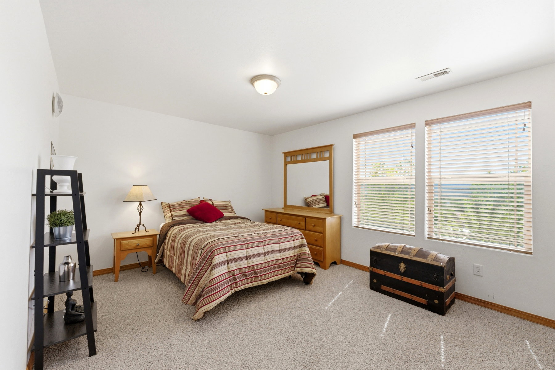 Spacious room featuring neutral carpet flooring and white walls