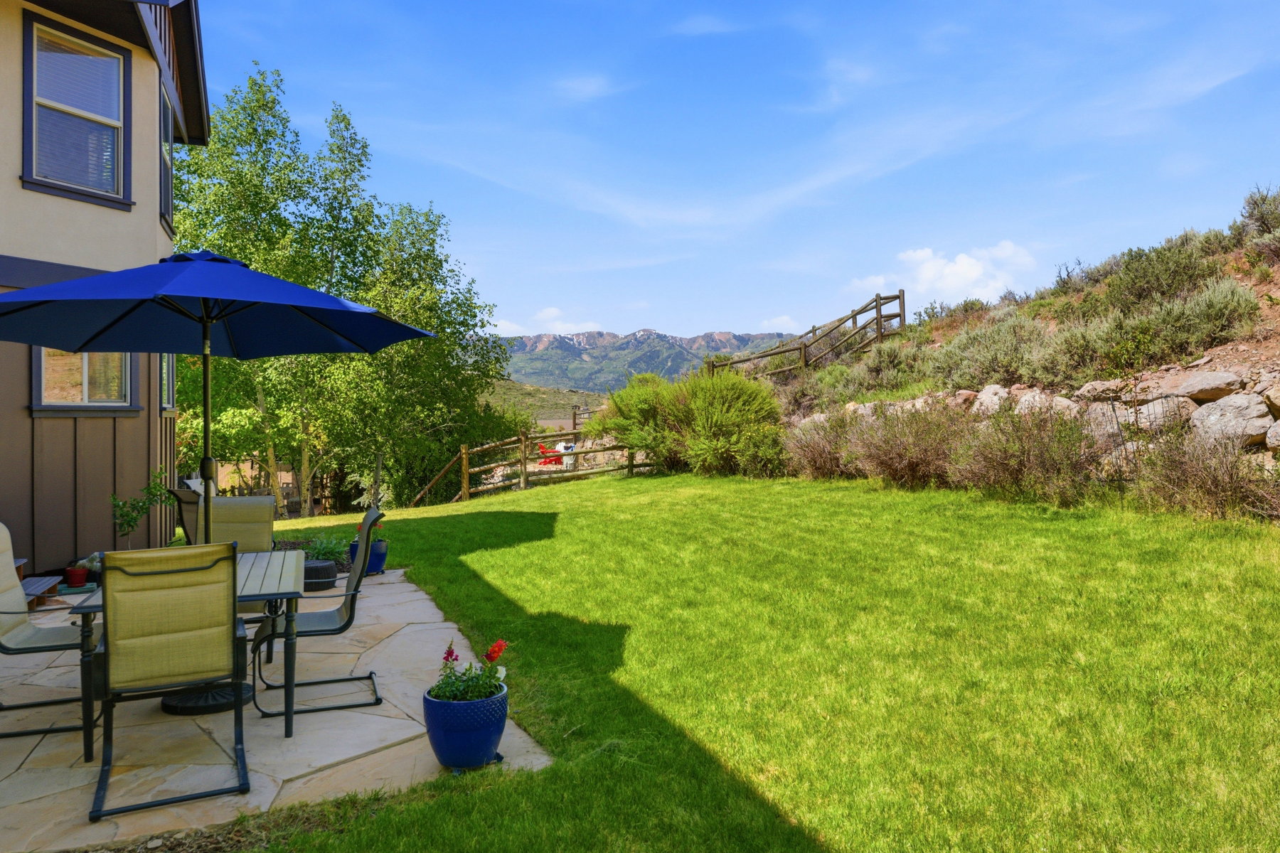 Expansive backyard featuring a stone patio and a vibrant green lawn