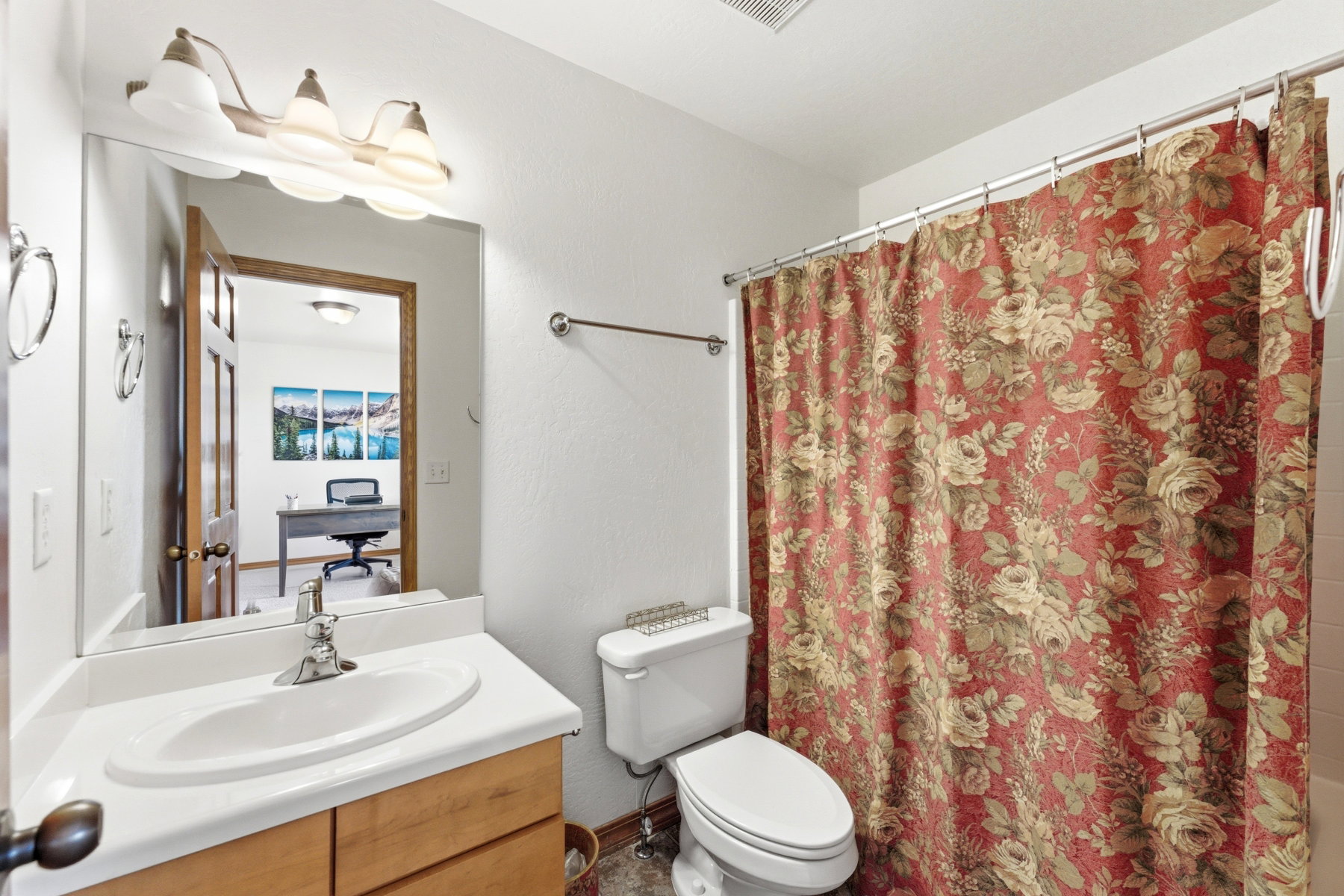 Bathroom with a single vanity, integrated sink, and wood-finish cabinetry