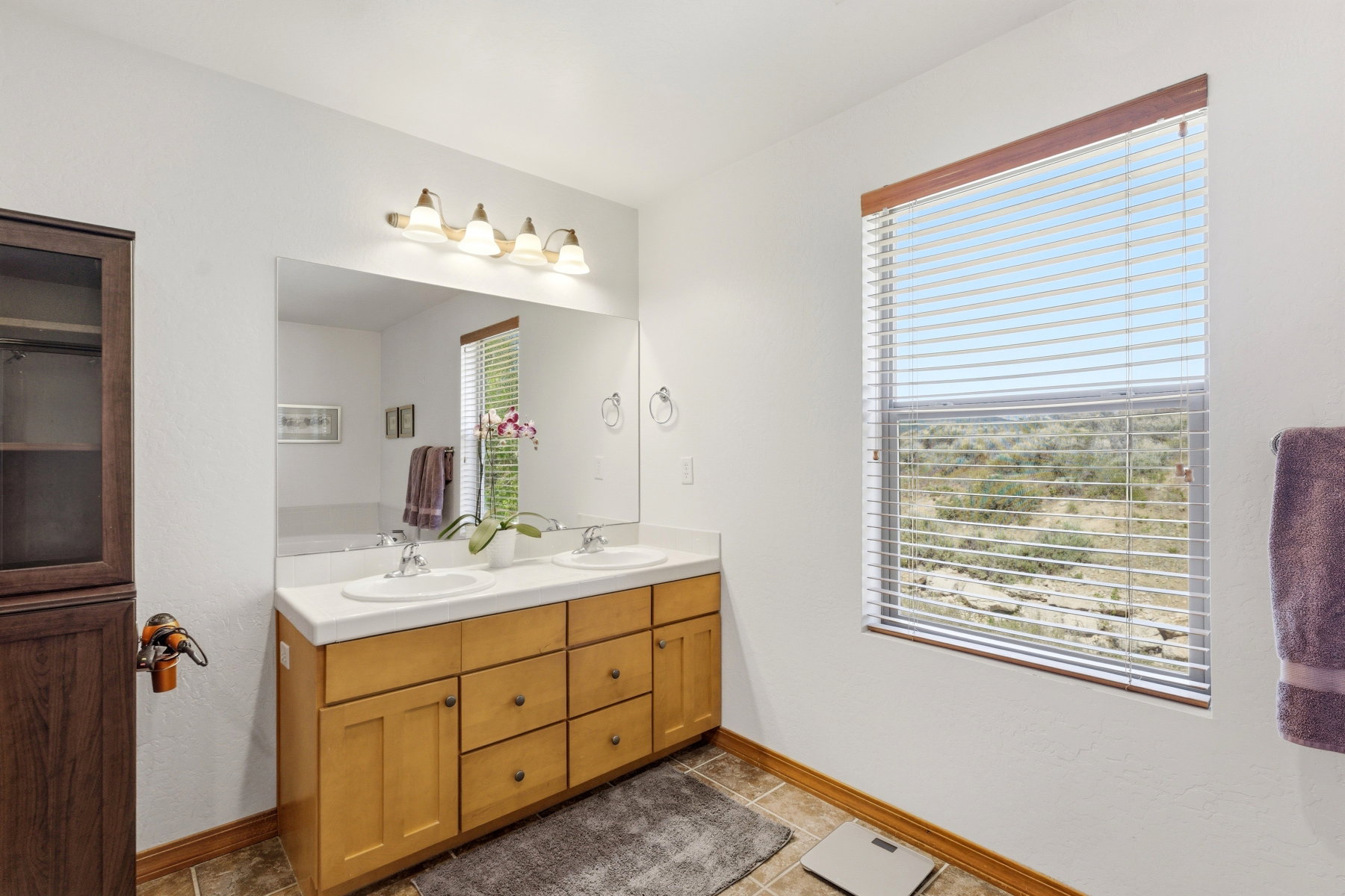 Double vanity with dual sinks, a large mirror, and a multi-bulb light fixture