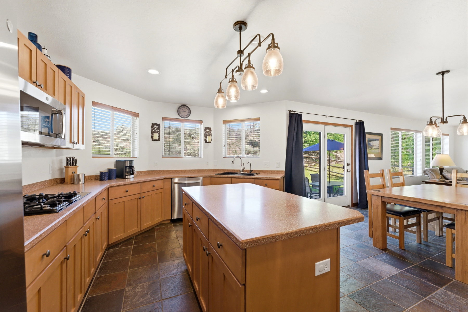 Open-concept kitchen with a central island, wood cabinetry, and stainless steel appliances