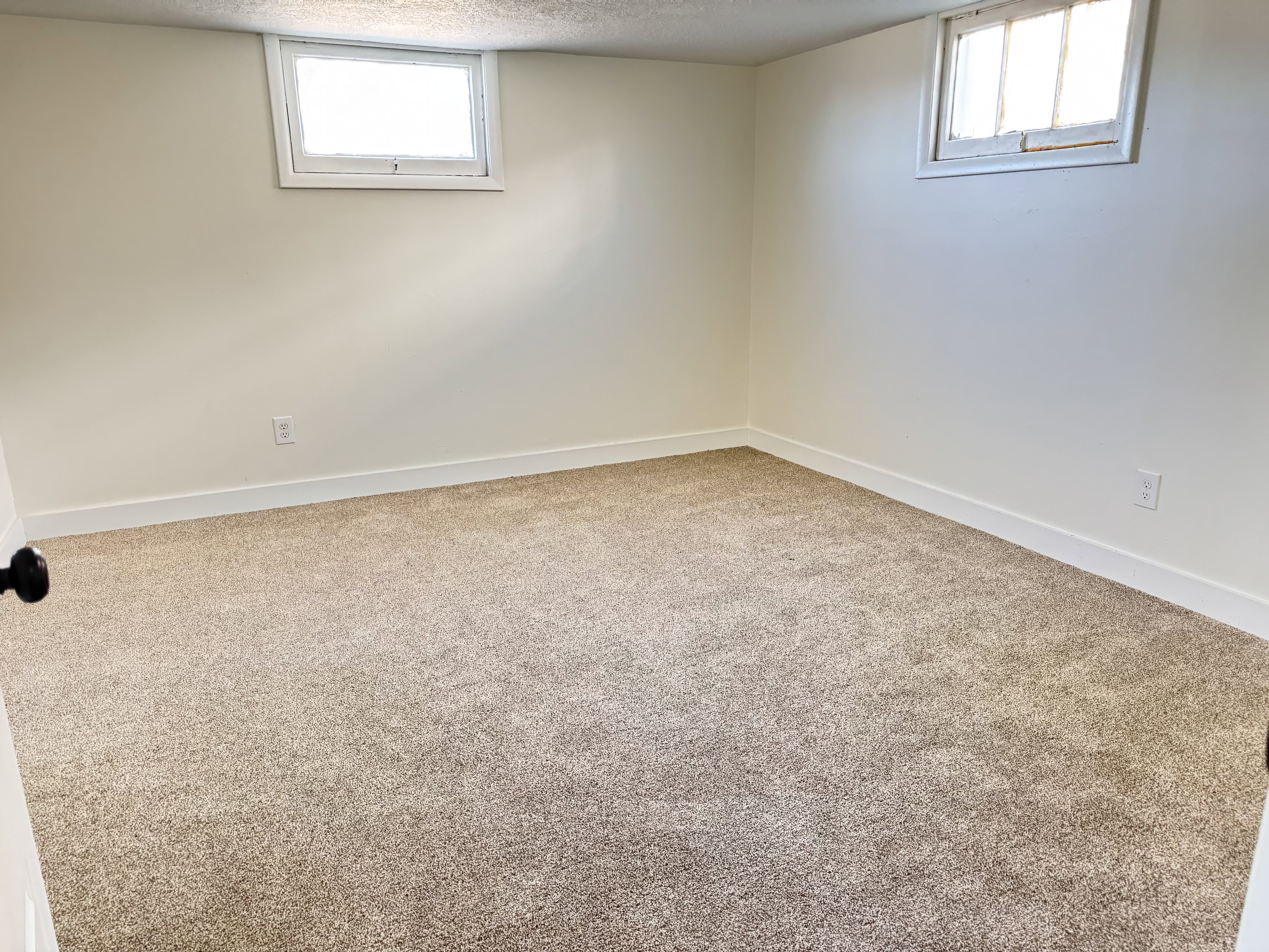 Carpeted room featuring light-colored walls and baseboards