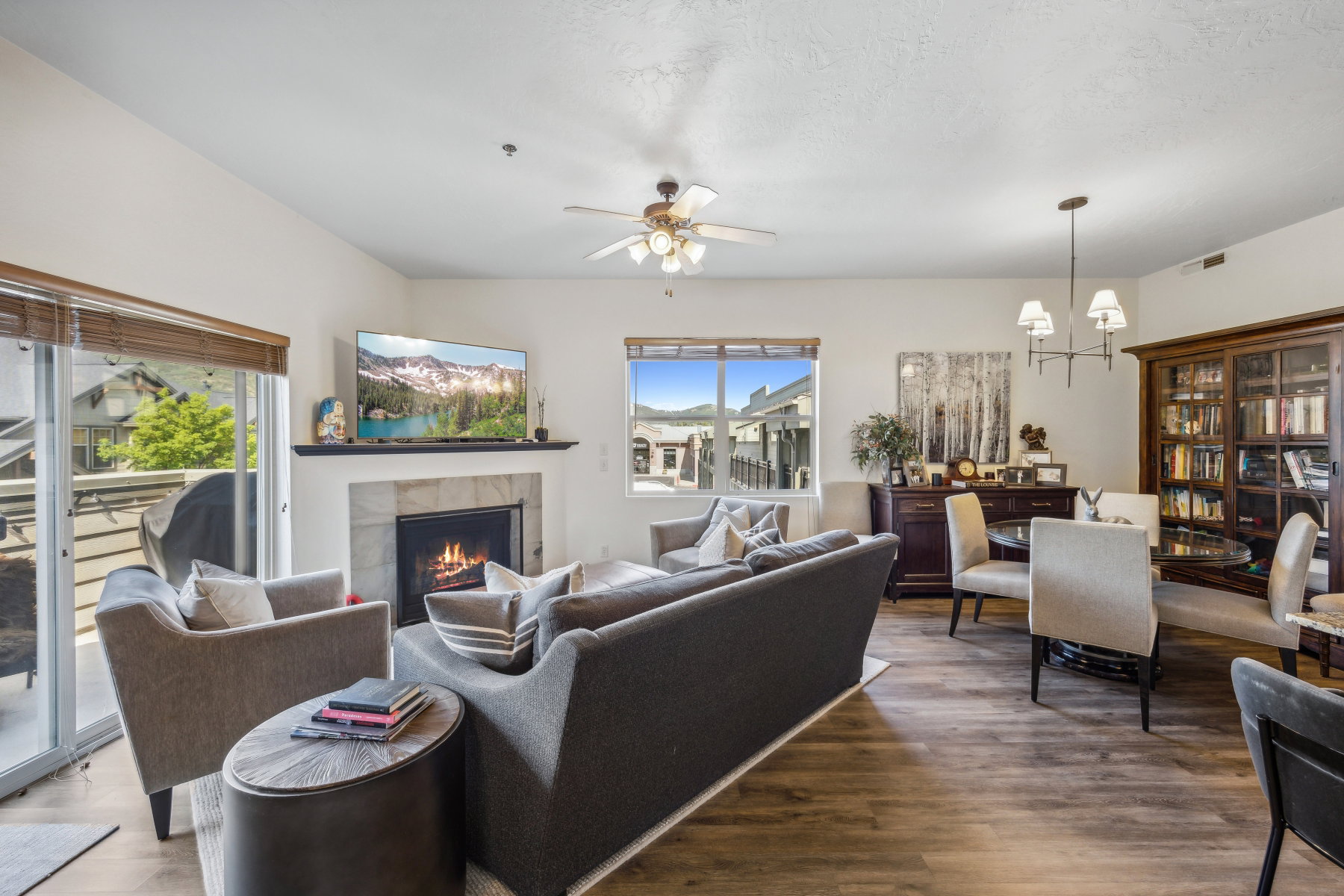 Spacious living area featuring wood-finish flooring, a tile-surround fireplace with a dark mantel, and recessed lighting