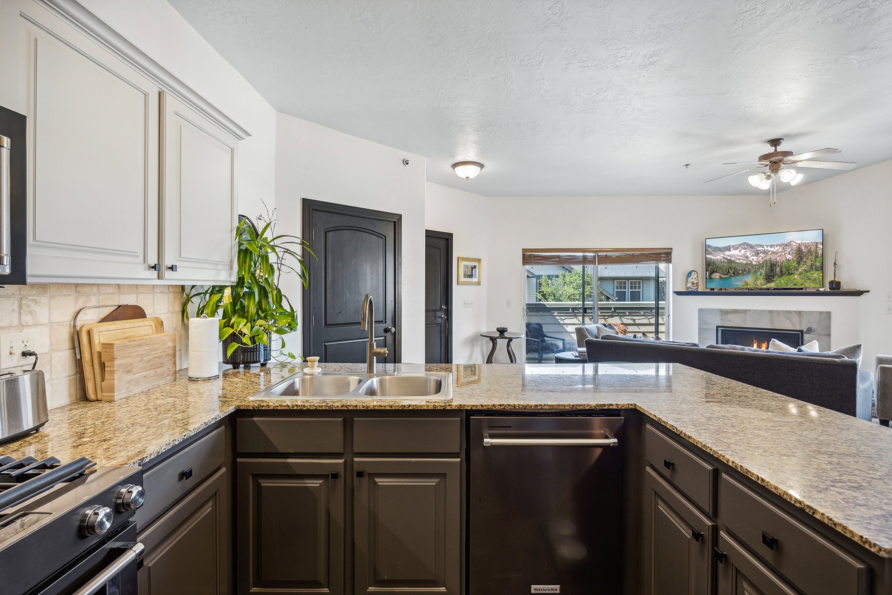 Kitchen island with a double basin sink, bronze faucet, and granite countertops