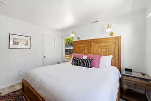 Bright bedroom featuring a large wood-finish headboard and frame