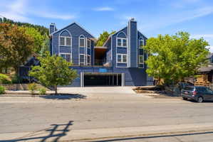 Multi-level structure featuring a distinctive blue exterior, white-framed windows, and covered parking