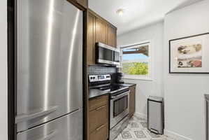 Kitchen featuring stainless steel appliances including a refrigerator, range, and microwave