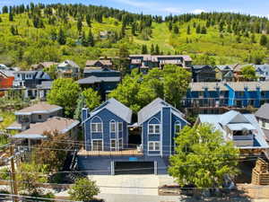 Two-story residential structures with blue siding and white trim, featuring multiple arched windows and gabled roofs