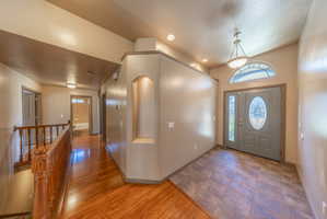Entryway featuring a decorative front door with an oval glass insert, a coordinating sidelight, and an arched transom window