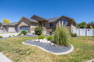 Tan exterior with stone accents and a gray shingle roof