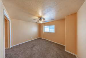 Carpeted room featuring a ceiling fan with integrated lighting, a window with horizontal blinds, and a built-in closet space