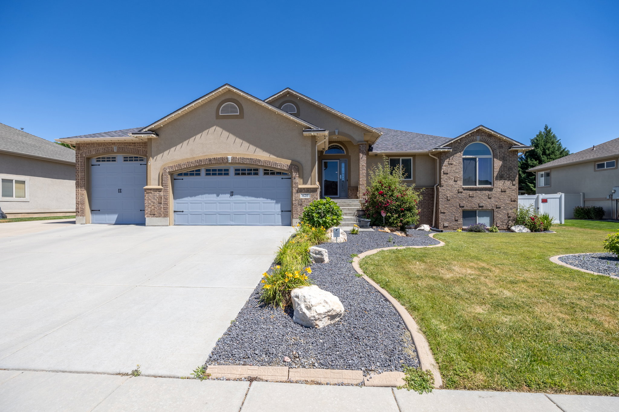 Two-story residence featuring a stucco and brick exterior, a two-car garage, and a concrete driveway