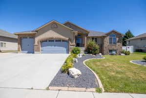 Two-story residence featuring a stucco and brick exterior, a two-car garage, and a concrete driveway
