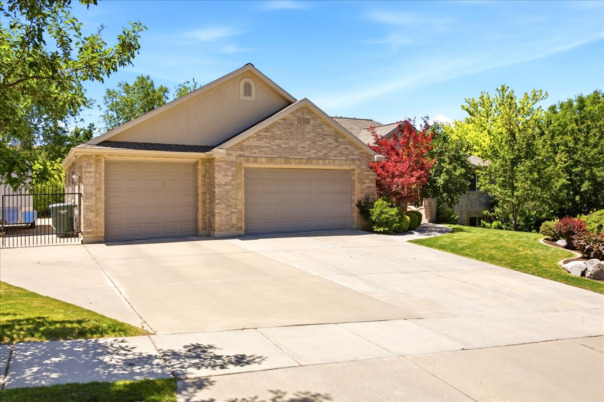 Exterior featuring a two-car garage, stone and stucco facade, and a concrete driveway