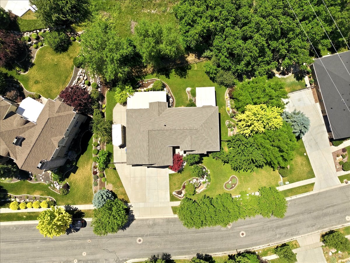 Aerial view of a residential property featuring a large, mature landscape