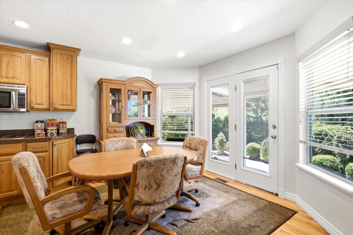 Bright dining area featuring natural wood-finish cabinetry and flooring