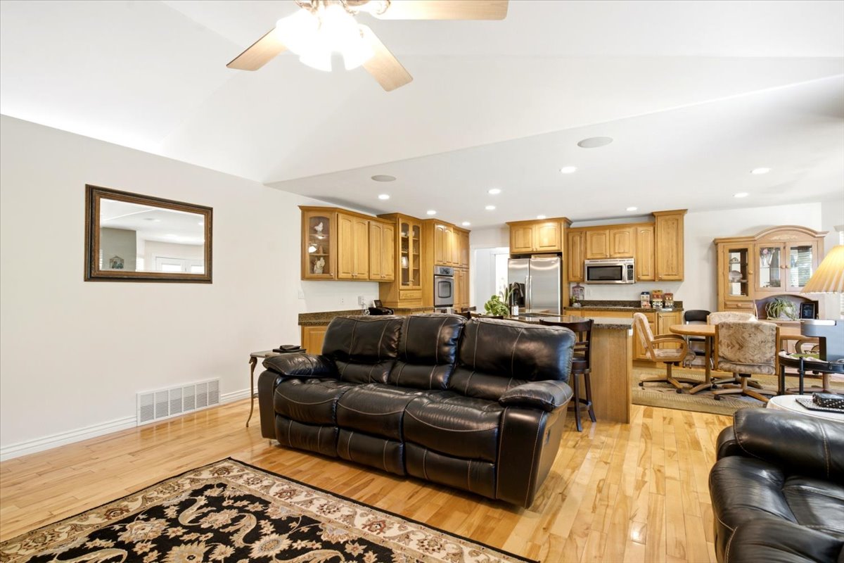 Open-concept living area featuring wood-finish flooring, recessed lighting, and a ceiling fan