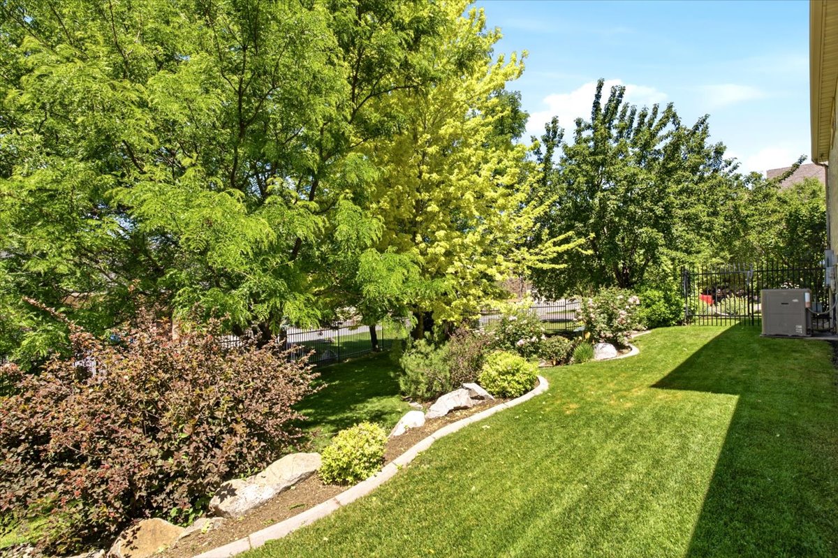 Expansive green lawn with mature trees and established landscaping
