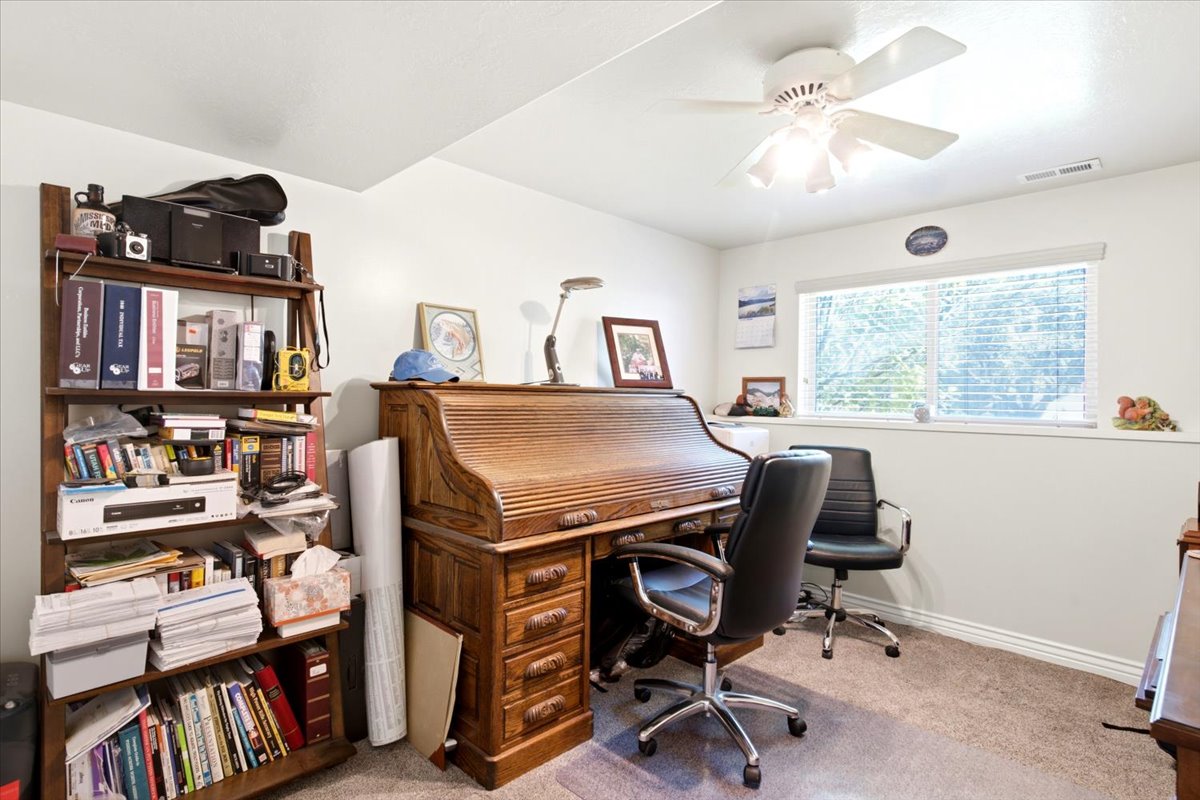 Carpeted room with a ceiling fan, a window with blinds, and white baseboards