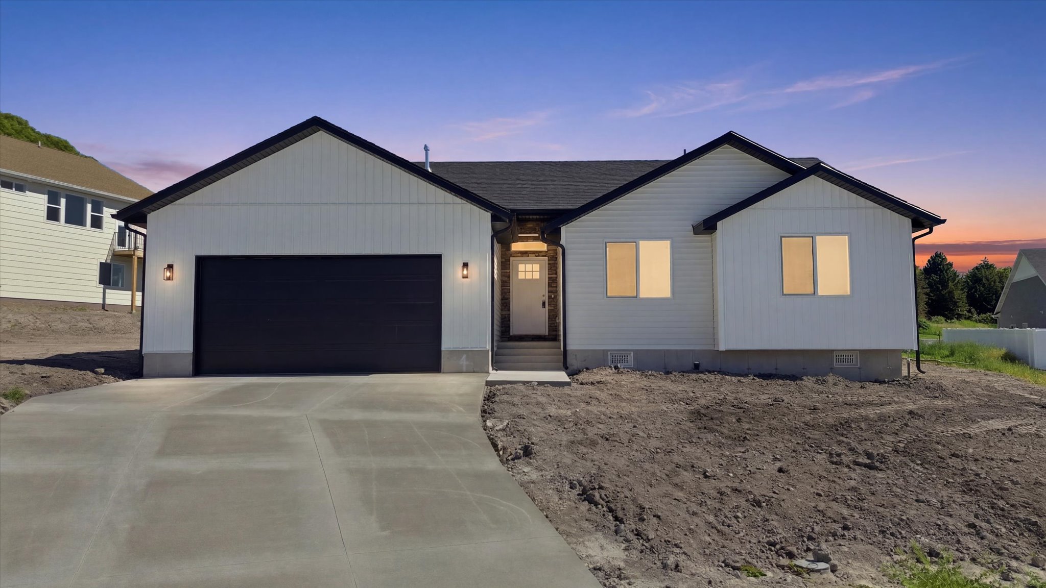 Contemporary single-story residence featuring white board and batten siding with black trim accents