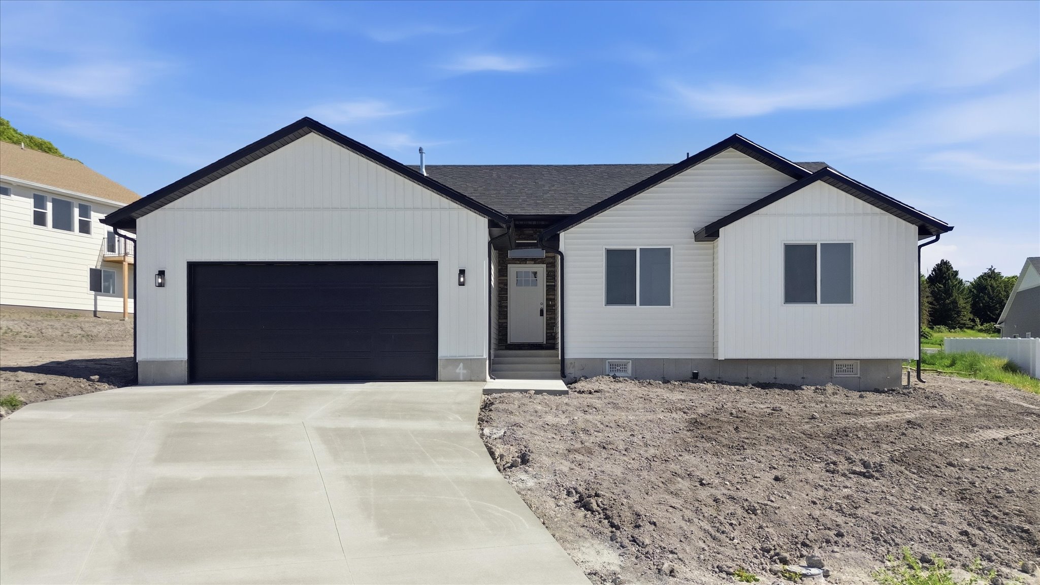 Contemporary ranch-style residence featuring white siding and a dark shingle roof