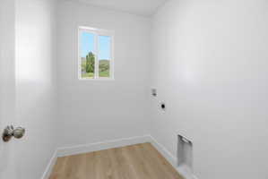 Bright interior space featuring wood-finish flooring, white baseboards, and a window