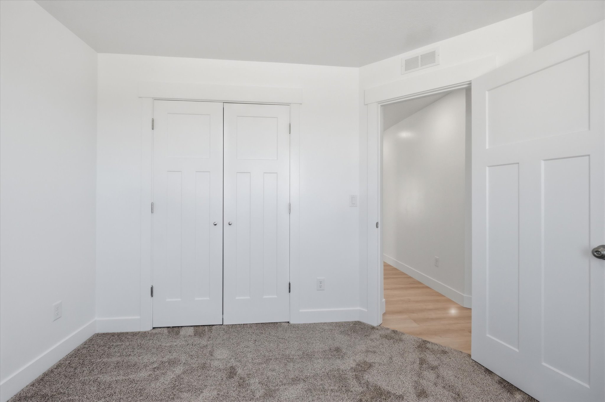 Neutral interior space with light gray carpet and white walls
