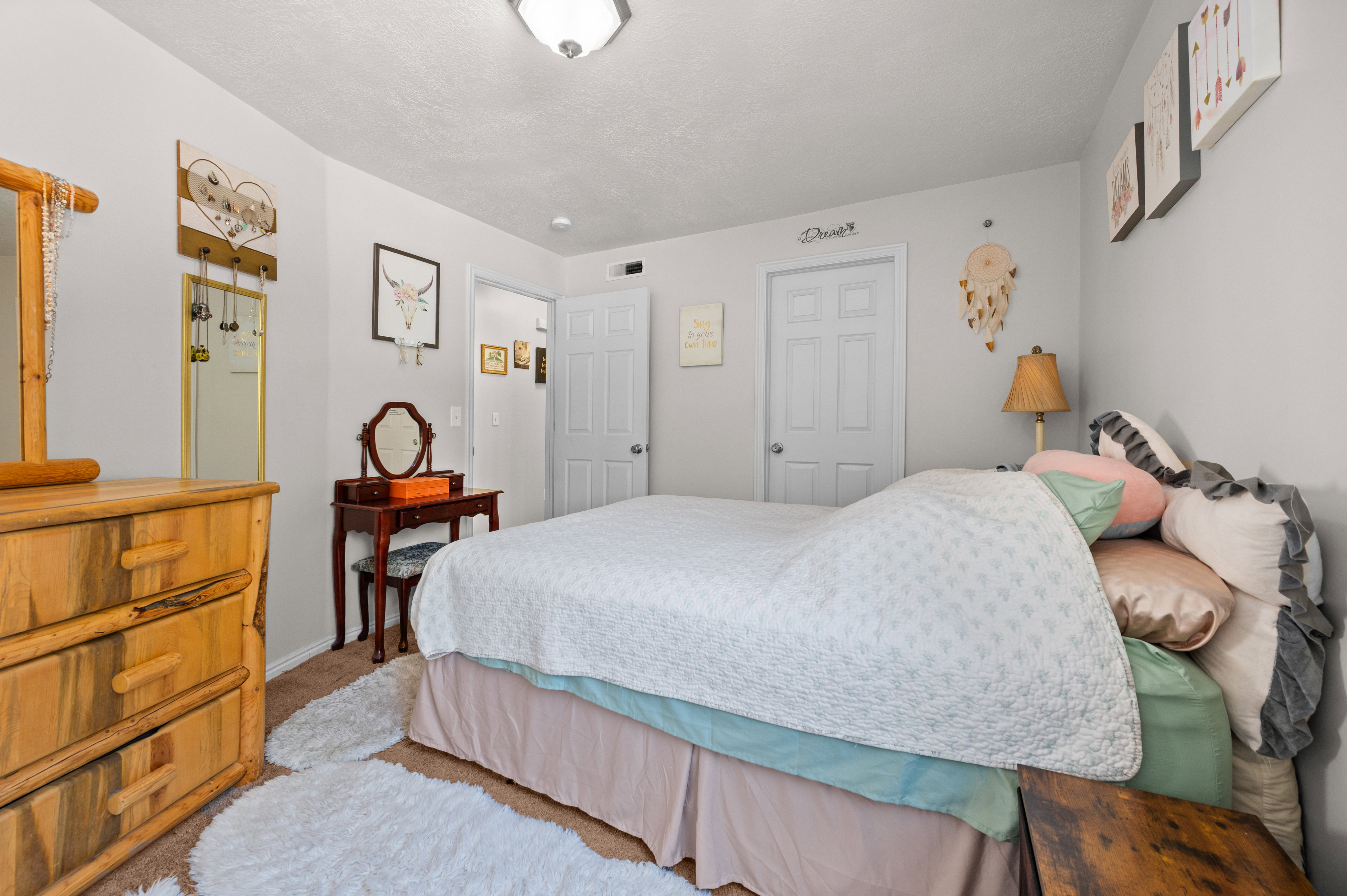 Carpeted room with a ceiling-mounted light fixture, white walls, and white paneled doors