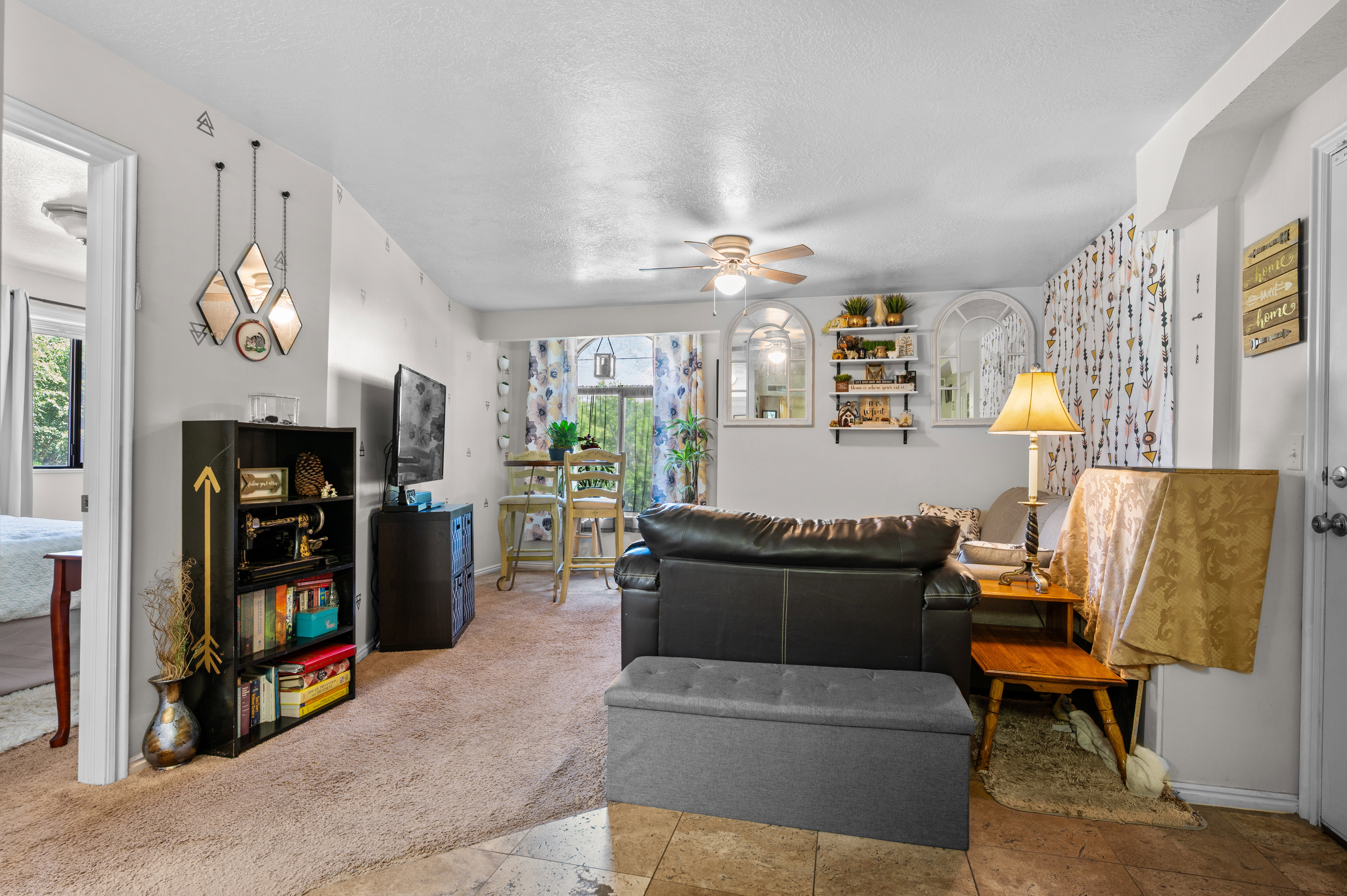 Open concept living area featuring a ceiling fan, recessed lighting, and a combination of carpet and tile flooring