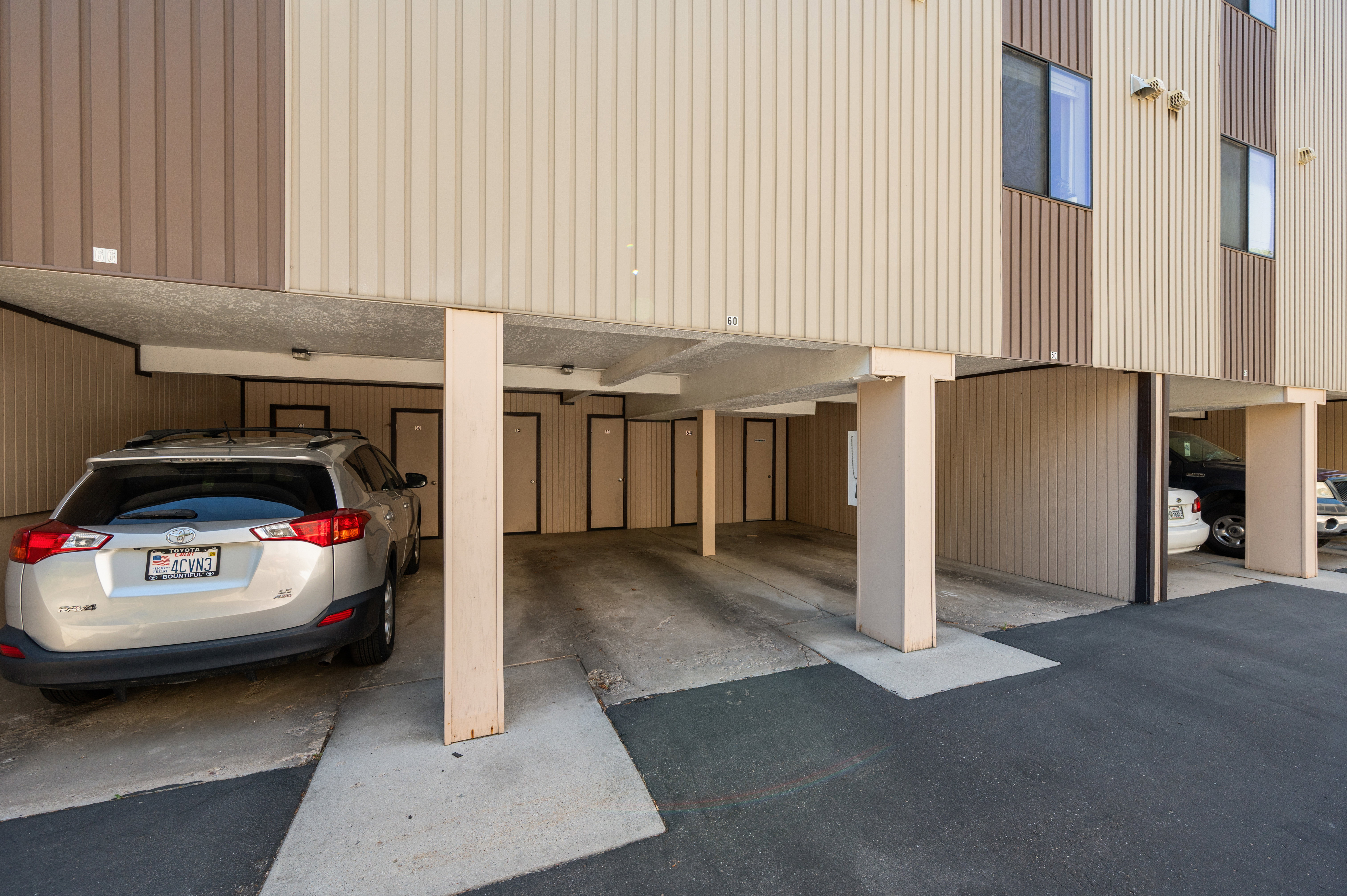 Carport parking area with a concrete foundation and asphalt approach
