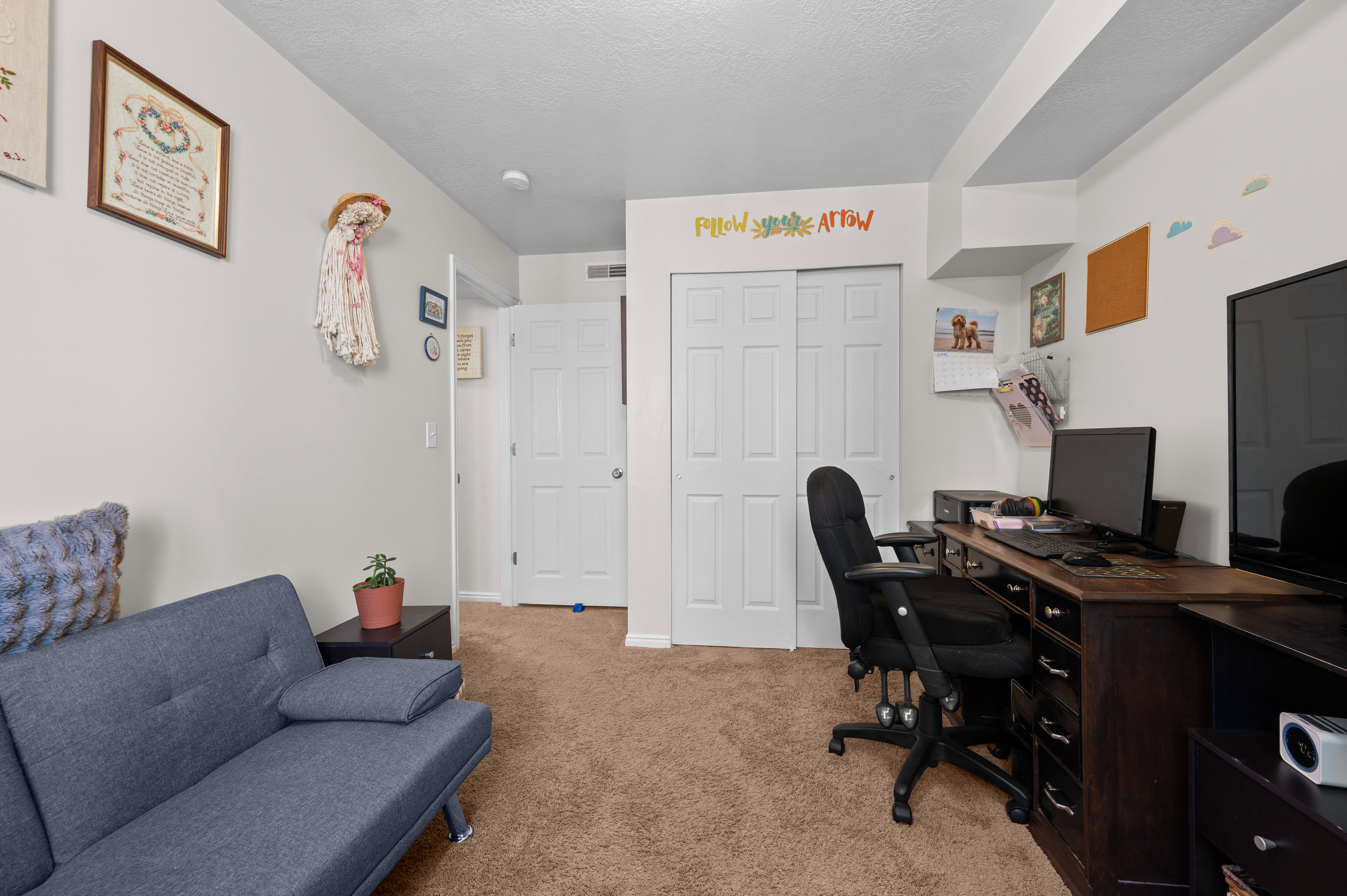 Carpeted room featuring a double bi-fold closet and a single panel door