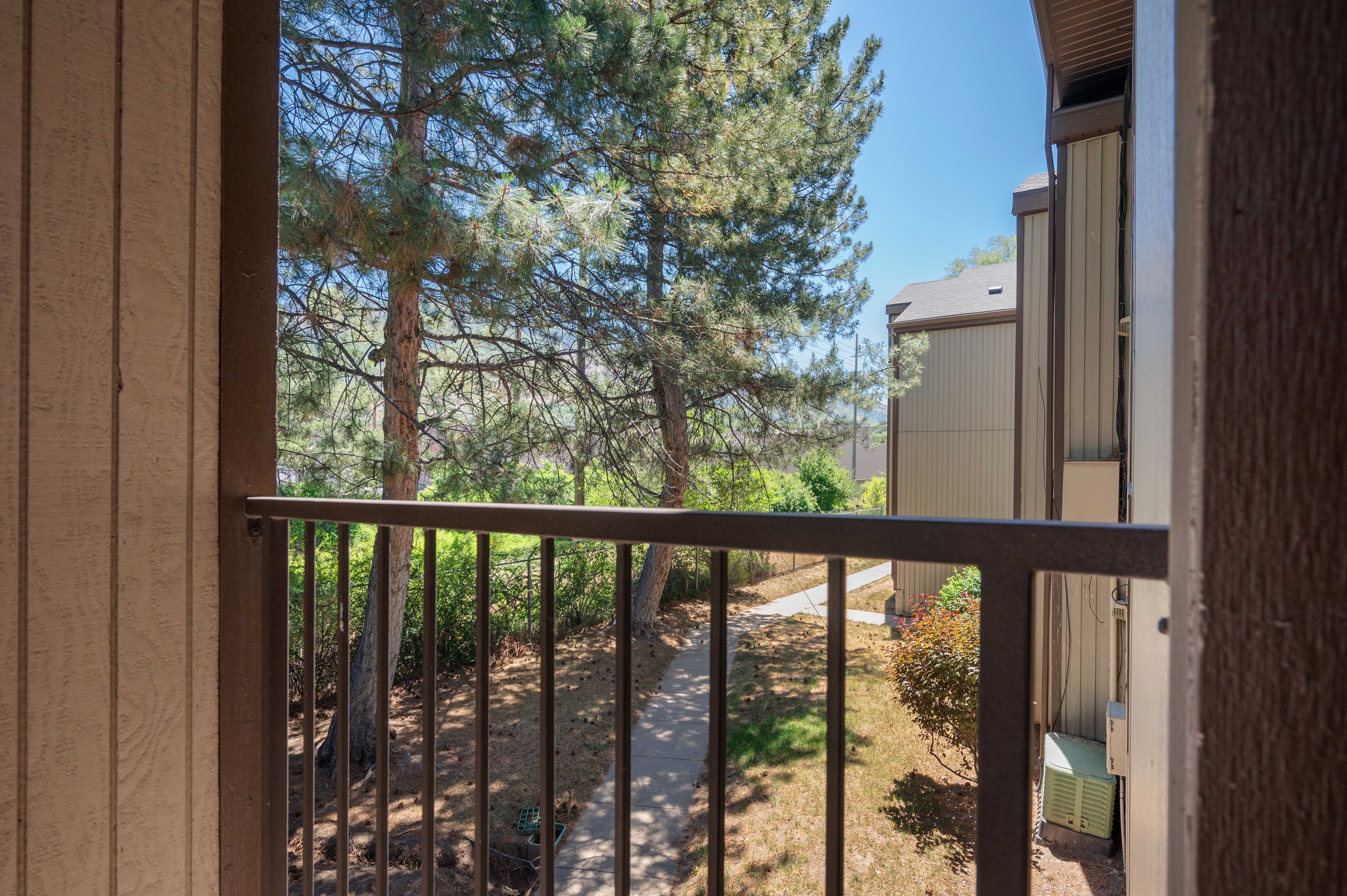 Balcony with metal railing and wood-look siding