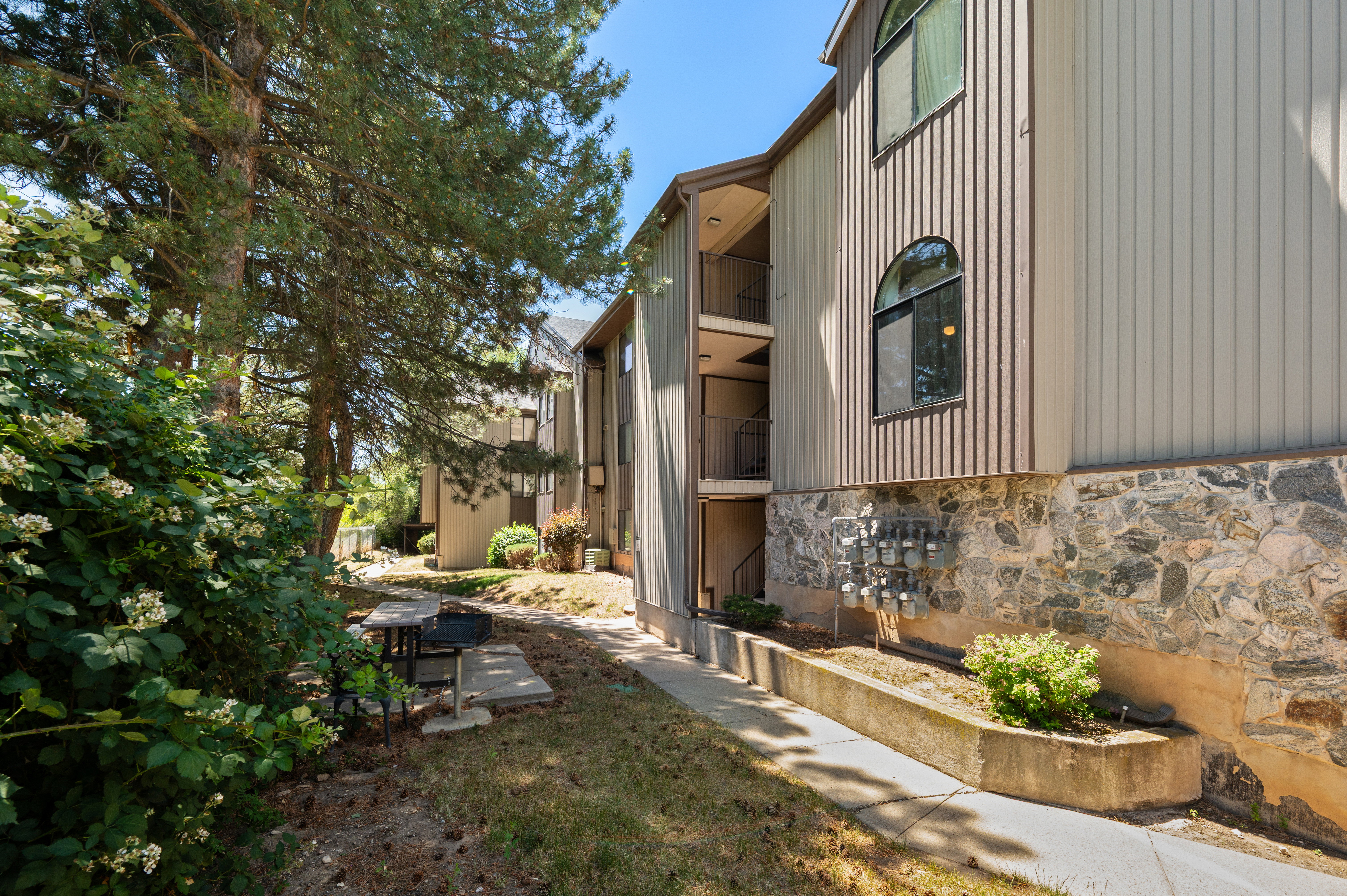 Building exterior featuring vertical siding, a stone facade, and arched windows
