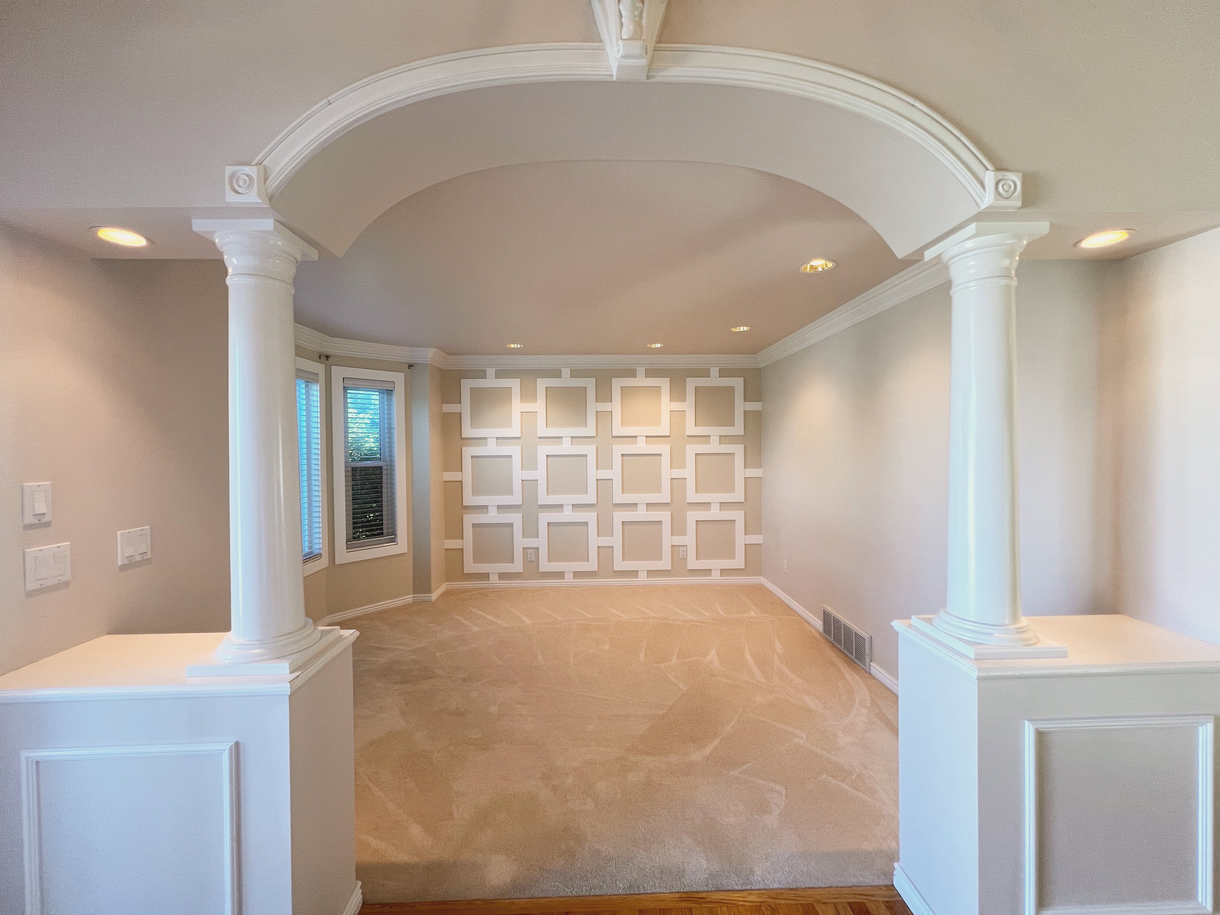 Archway entry featuring classic columns and decorative trim