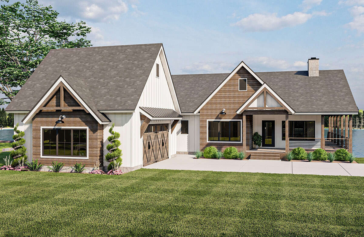 Craftsman-style exterior featuring a covered front porch, wood-finish siding accents, a two-car garage with barn-style doors, a prominent chimney, and a durable shingle roof